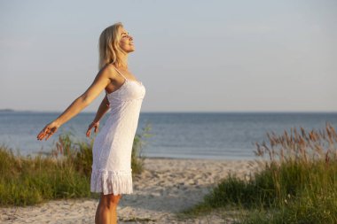 gün batımında sahilde mutlu kadın