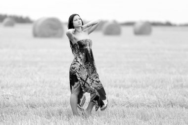 Genç özgür bir kadın samanlı bir tarlada