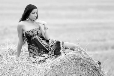 Genç özgür bir kadın samanlı bir tarlada