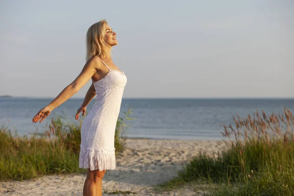 Mulher feliz na praia ao pôr do sol — Fotografia de Stock