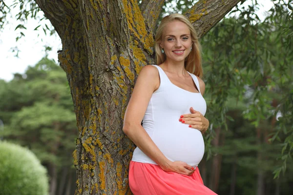 Fiatal boldog terhes lány a parkban — Stock Fotó