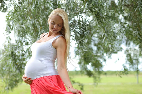 Jeune fille enceinte heureuse dans le parc — Photo