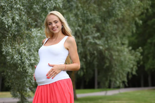 Ung glad gravid flicka i parken — Stockfoto