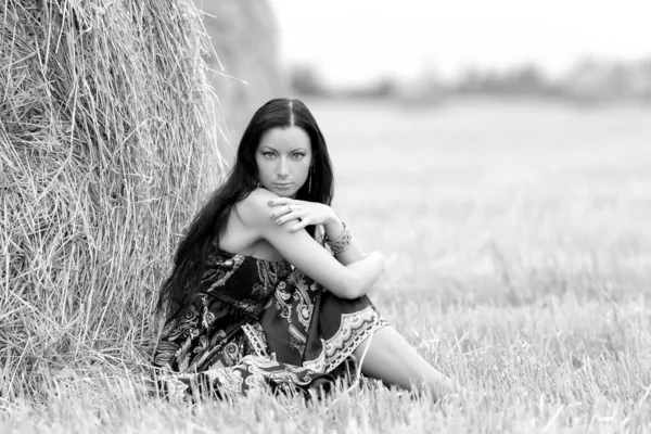 Young free woman in a field with hay — Stock Photo, Image