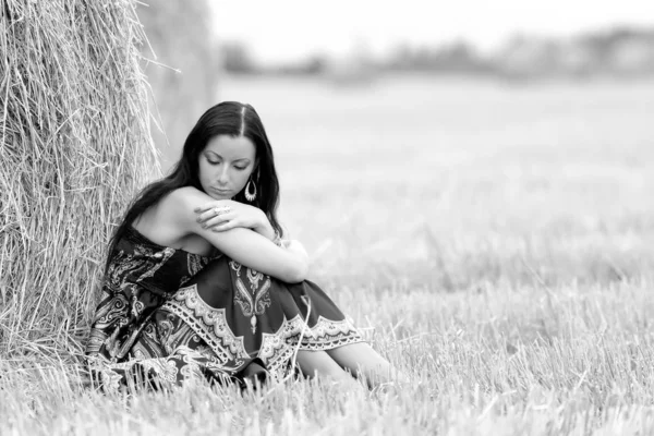 Jovem mulher livre em um campo com feno — Fotografia de Stock