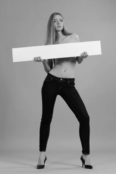 Молодая сексуальная девушка с белыми знаками для текста — стоковое фото