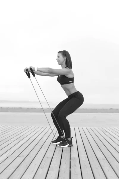 Žena dělá cvičení s gumičkou, fitness venku — Stock fotografie
