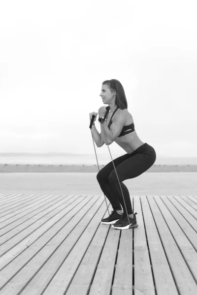 Mujer haciendo ejercicios con banda elástica, fitness al aire libre —  Fotos de Stock