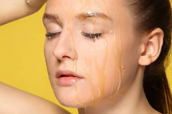 Kvinna med honung på hennes ansikte. — Stockfoto