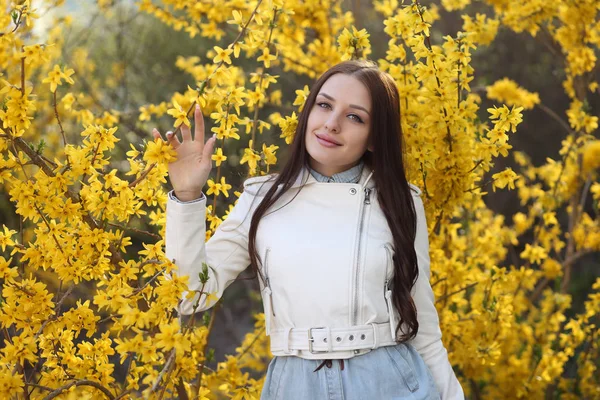 Młoda dziewczyna pozowanie w krzakach z wiosennych kwiatów — Zdjęcie stockowe