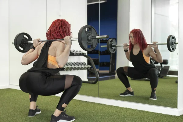 Jong meisje in de sportschool doen kraakactie — Stockfoto