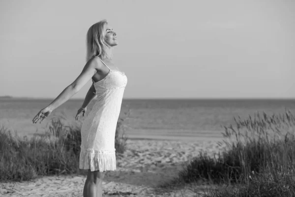 Glückliche Frau am Strand bei Sonnenuntergang — Stockfoto