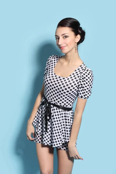 Ung vacker brunett i en polka dot klänning — Stockfoto