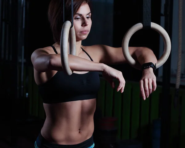 Woman athlete doing ring dips in the gym — Stock Photo, Image