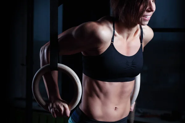 Femme athlète faire anneau trempettes dans la salle de gym — Photo