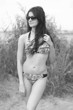 Kumsalda bikinili genç bir kadın.