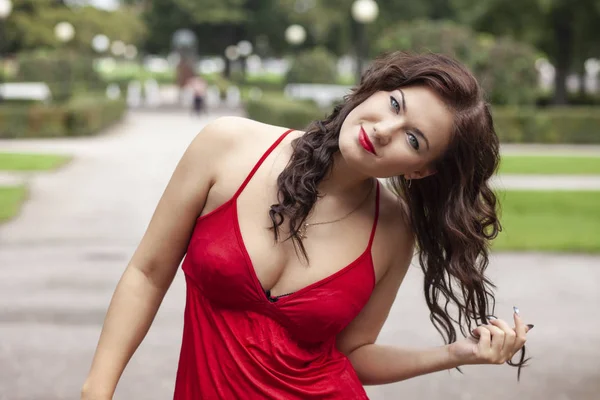 Junges sexy Mädchen in rotem Kleid im Park — Stockfoto
