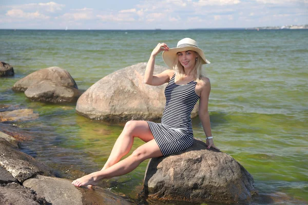 Gelukkige vrouw op het strand op zee bij zonsondergang. — Stockfoto