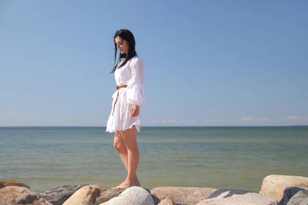 Giovane ragazza felice in un abito bianco in riva al mare — Foto Stock