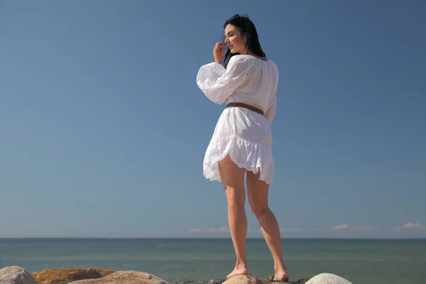 Deniz kenarındaki beyaz elbiseli mutlu genç kız — Stok fotoğraf