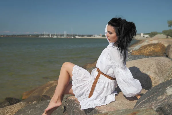 Giovane ragazza felice in un abito bianco in riva al mare — Foto Stock