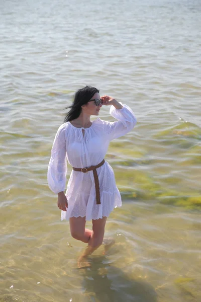 Joven chica feliz en un vestido blanco junto al mar — Foto de Stock