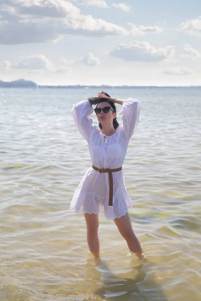 Joven chica feliz en un vestido blanco junto al mar — Foto de Stock
