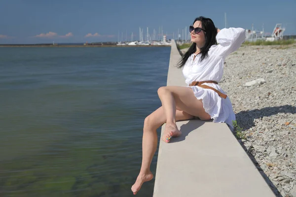 Giovane ragazza felice in un abito bianco in riva al mare — Foto Stock