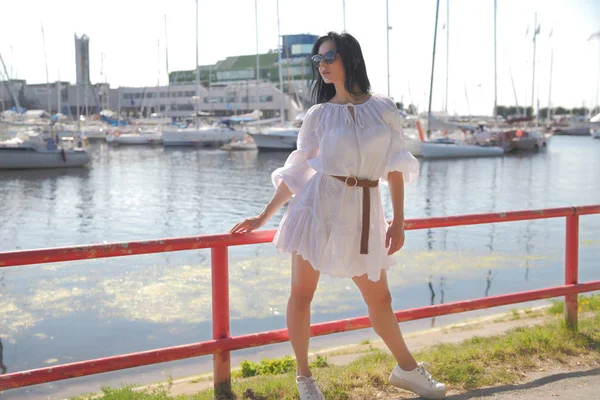 Jovem menina feliz em um vestido branco junto ao mar — Fotografia de Stock