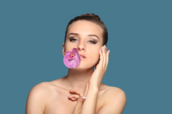 Портрет молодой девушки с цветком орхидеи — стоковое фото