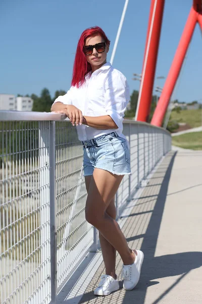 Jovem menina feliz na camisa e calções jeans — Fotografia de Stock