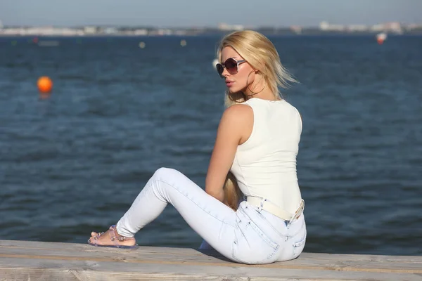 Молодая стильная девушка в легких джинсах и майке — стоковое фото