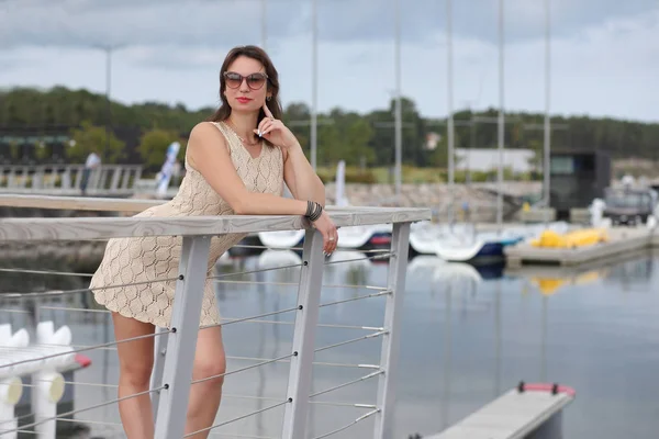 Mulher em um vestido esbelto perto dos iates — Fotografia de Stock