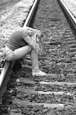 Kızgın kız raylarda oturuyor.