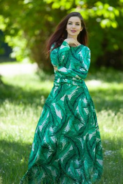 Bahçede uzun yeşil elbiseli genç bir kadın