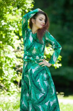 Bahçede uzun yeşil elbiseli genç bir kadın