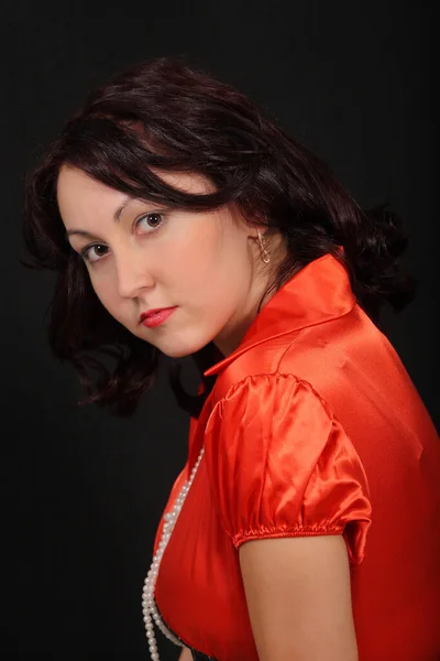 young sexy girl in a red blouse on a black background