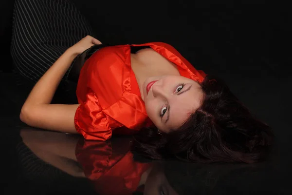 黒い背景をした赤いブラウスの若いセクシーな女の子 — ストック写真