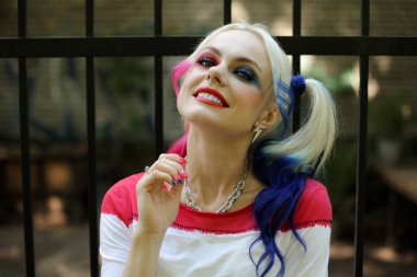 Kostümcü sarışın kız Harley Quinn kostümlü.