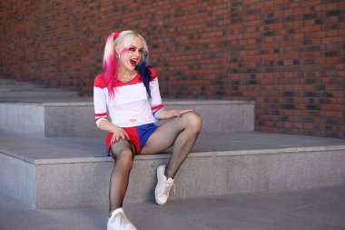Kostümcü sarışın kız Harley Quinn kostümlü.