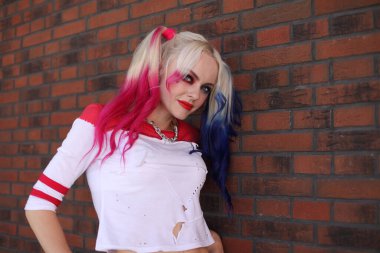 Kostümcü sarışın kız Harley Quinn kostümlü.