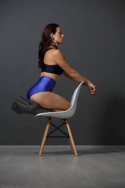 İçerde poz veren şık kıyafetli güçlü bir kadın.