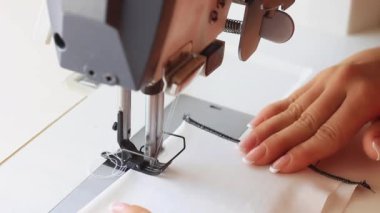 Endüstriyel bir çift iğneye dikiş atan bir kadın..