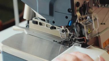 Endüstriyel dikiş makinesine dikiş diken bir kadın. Üst Kilit