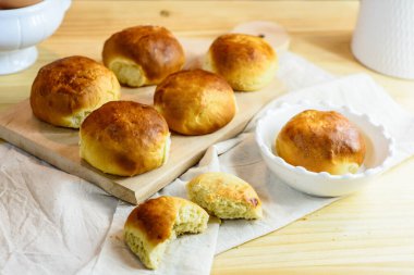 Taze çörek, mutfak gereçleri ve ahşap arka planda yumurtalar, ev yapımı fırın.