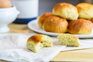 Taze çörek, mutfak gereçleri ve ahşap arka planda yumurtalar, ev yapımı fırın.