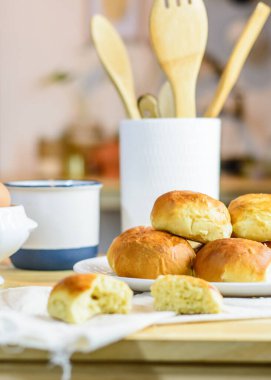 Taze çörek, mutfak gereçleri ve ahşap arka planda yumurtalar, ev yapımı fırın.