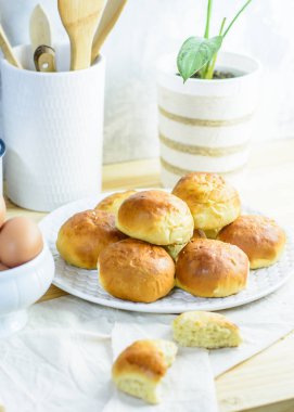 Taze çörek, mutfak gereçleri ve ahşap arka planda yumurtalar, ev yapımı fırın.