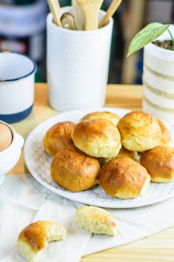 Taze çörek, mutfak gereçleri ve ahşap arka planda yumurtalar, ev yapımı fırın.