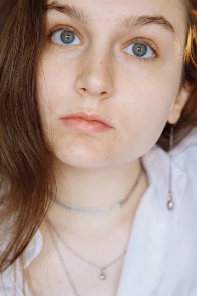 Doğal özellikleri olan esmer bir kız izleyiciye delici bir şekilde bakıyor.. 